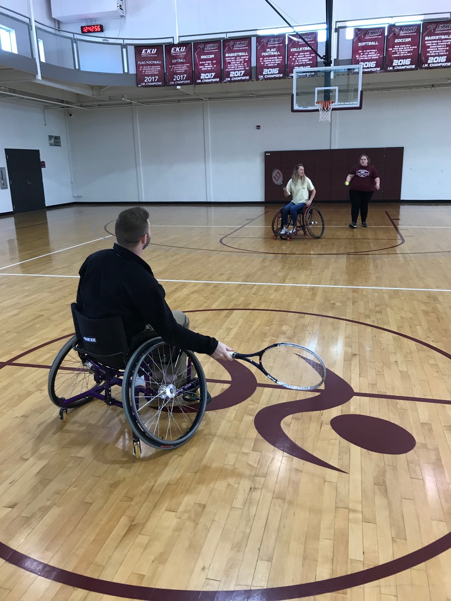Participants playing wheelchair tennis